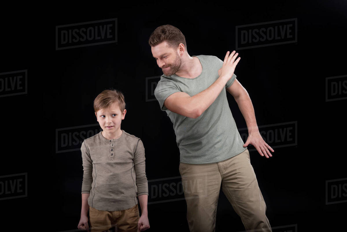 Angry father threatening and gesturing to scared little son, family