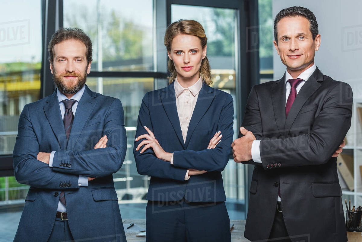 Portrait of lawyers in suits with arms crossed looking at camera while