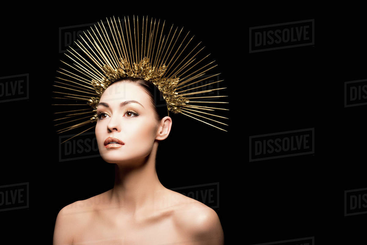 Glamorous naked model posing in golden headpiece isolated on black - Stock Photo - Dissolve