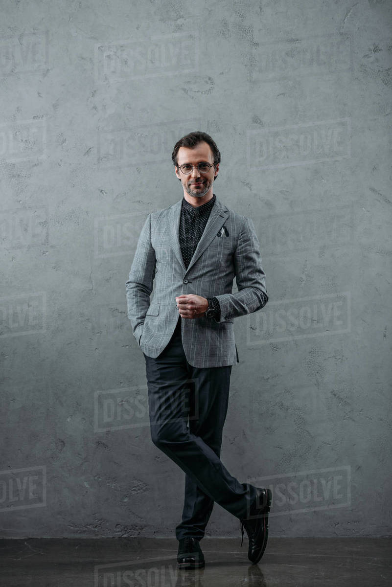 Full length view of stylish middle aged businessman looking at camera