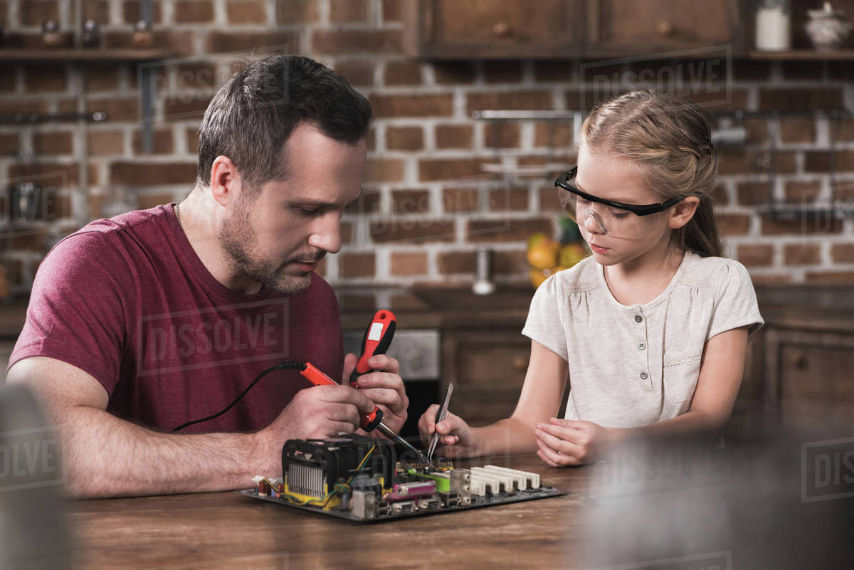 Father and daughter brazing at home, concentrated process Stock Photo Dissolve