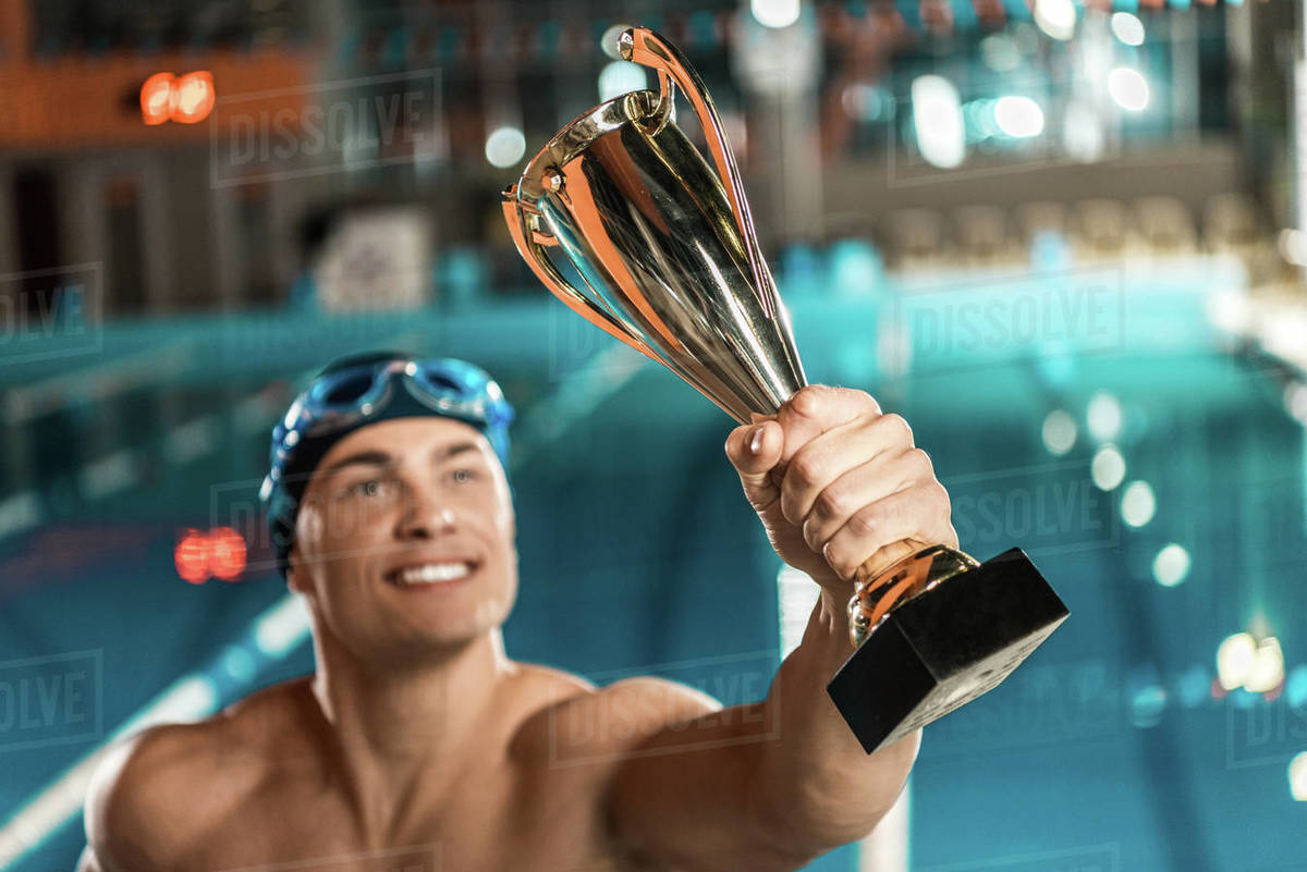 Swimmer with trophy cup at competition swimming pool Stock Photo