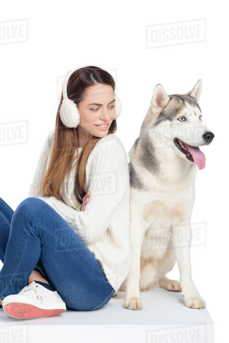 husky dog and beautiful smiling girl in winter earmuffs, isolated