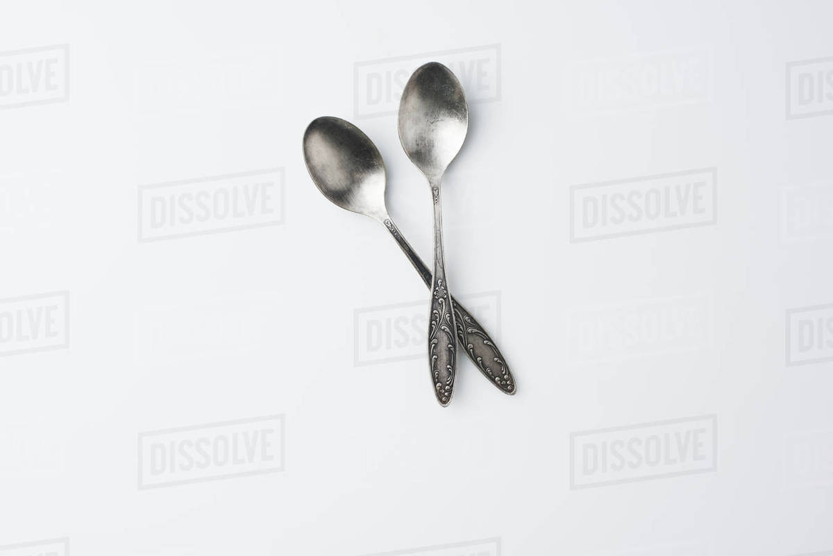 top view of crossed spoons isolated on white Stock Photo Dissolve
