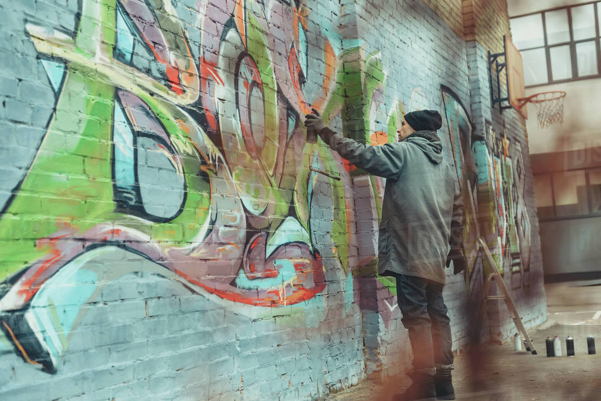 Street Artist Painting Colorful Graffiti On Wall Stock Photo Dissolve