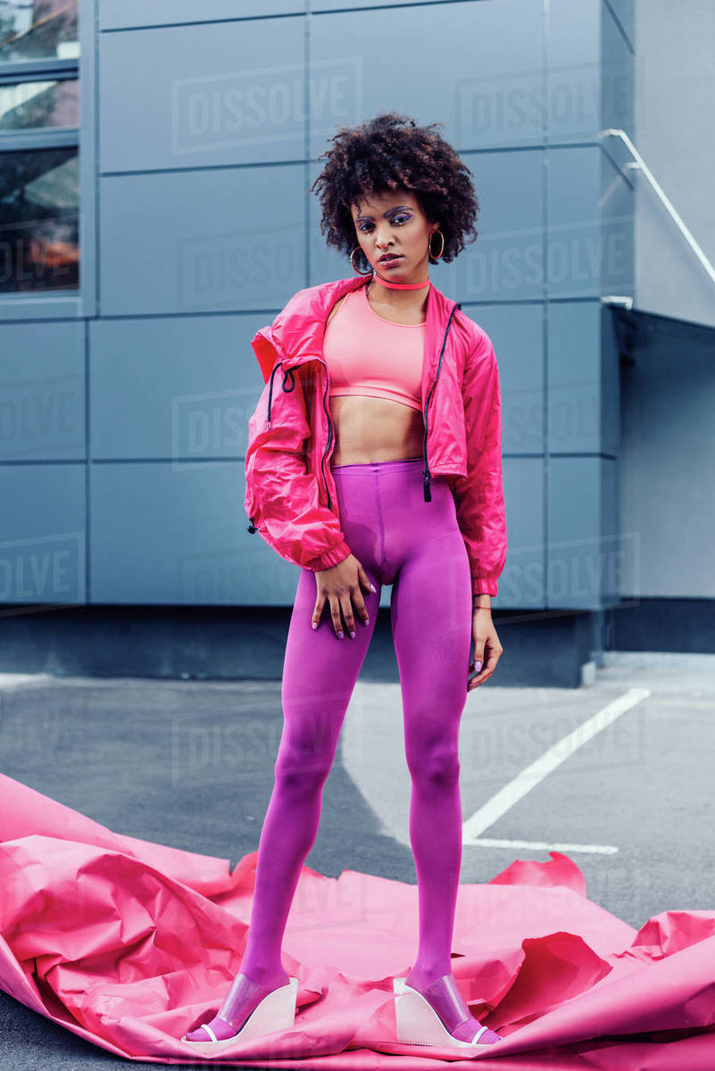 Fashionable African American girl posing in 80s style clothes with
