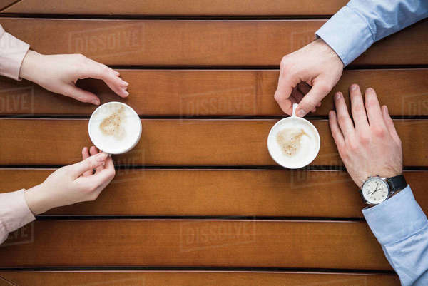 cropped image of man and woman sitting at table with coffee - Royalty ...