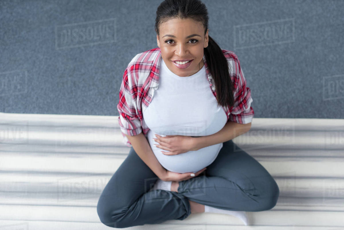 overhead view of smiling african american pregnant woman practicing