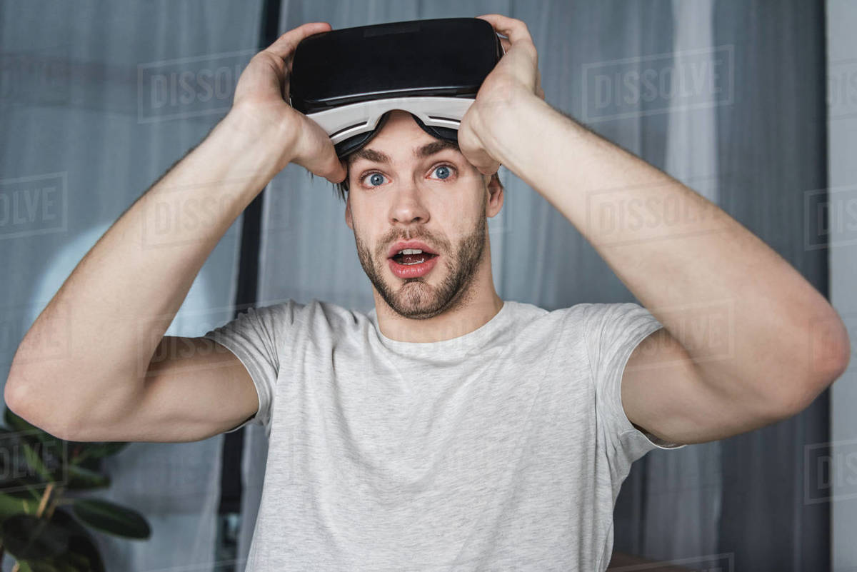 shocked young man in virtual reality headset Stock Photo Dissolve