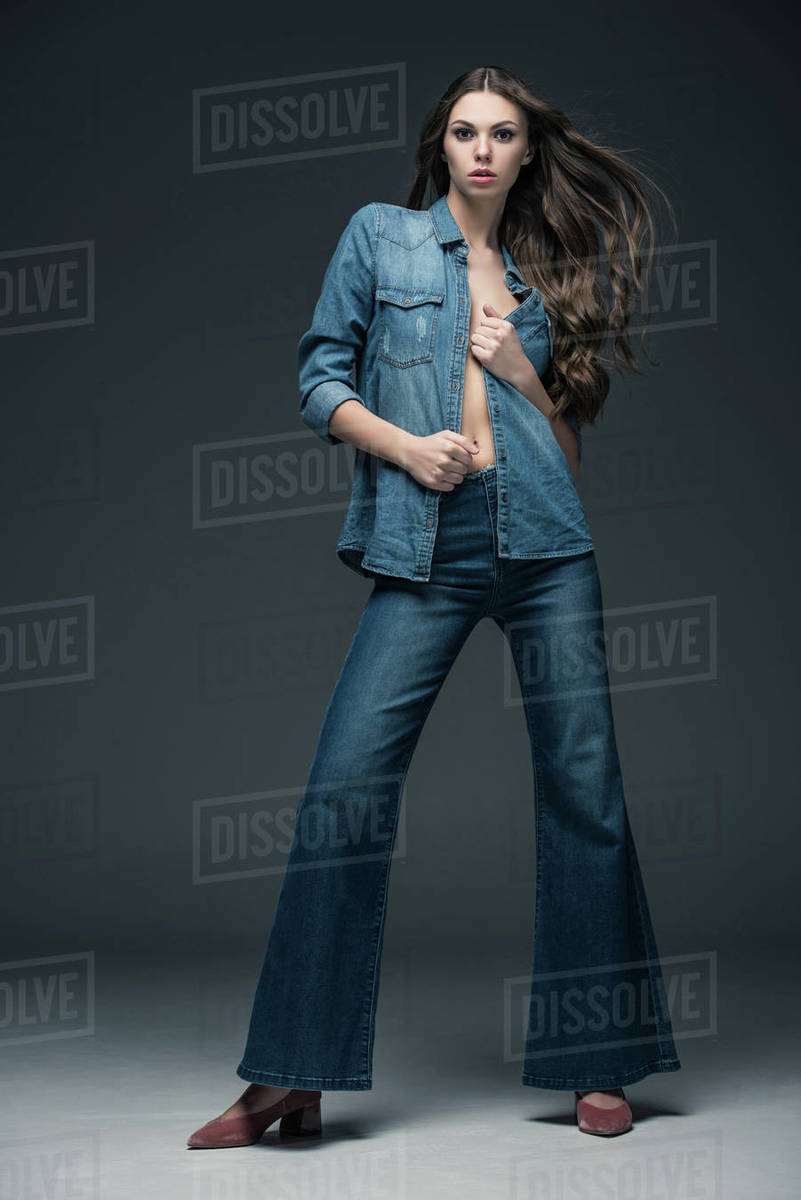 attractive sexy girl posing in denim clothes, on grey Stock Photo