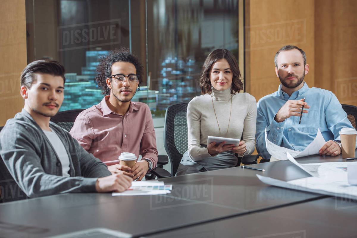 Group of businesspeople sitting in conference room together and looking at camera Royalty-free stock photo