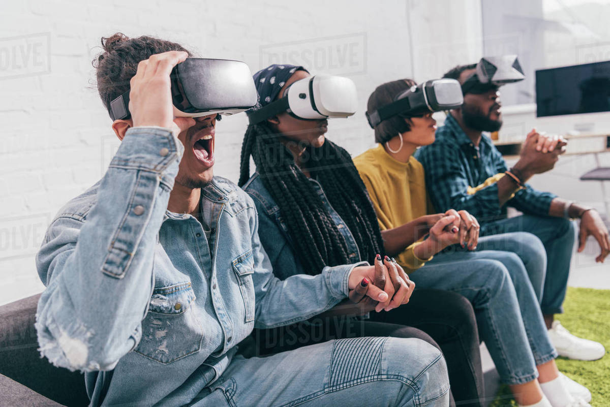 Group of young multicultural friends using virtual reality headsets