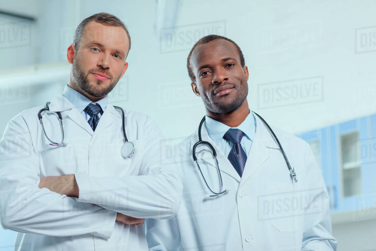 Portrait of multiracial group of doctors in medical uniforms in clinic
