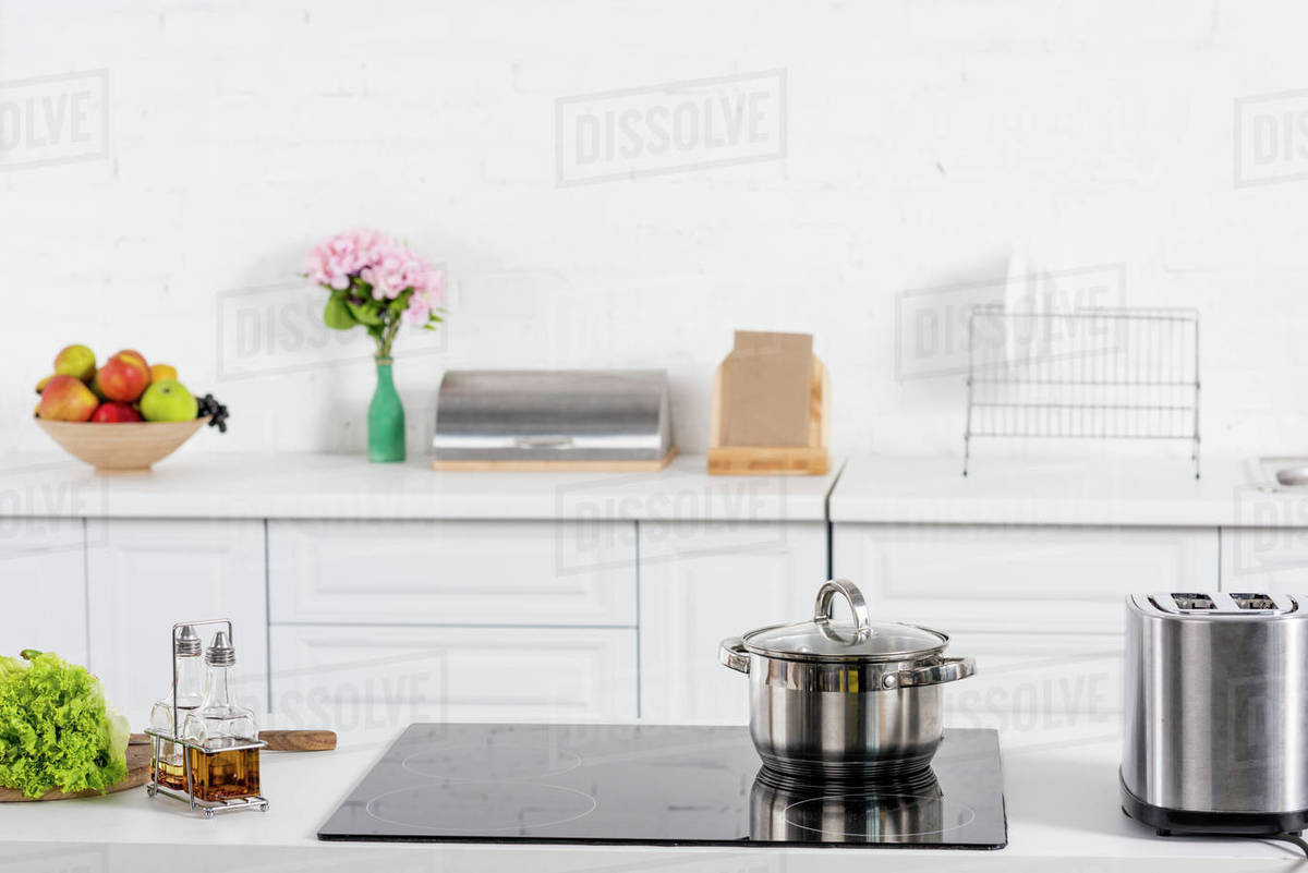 Toaster and electric stove with saucepan on kitchen Stock Photo Dissolve