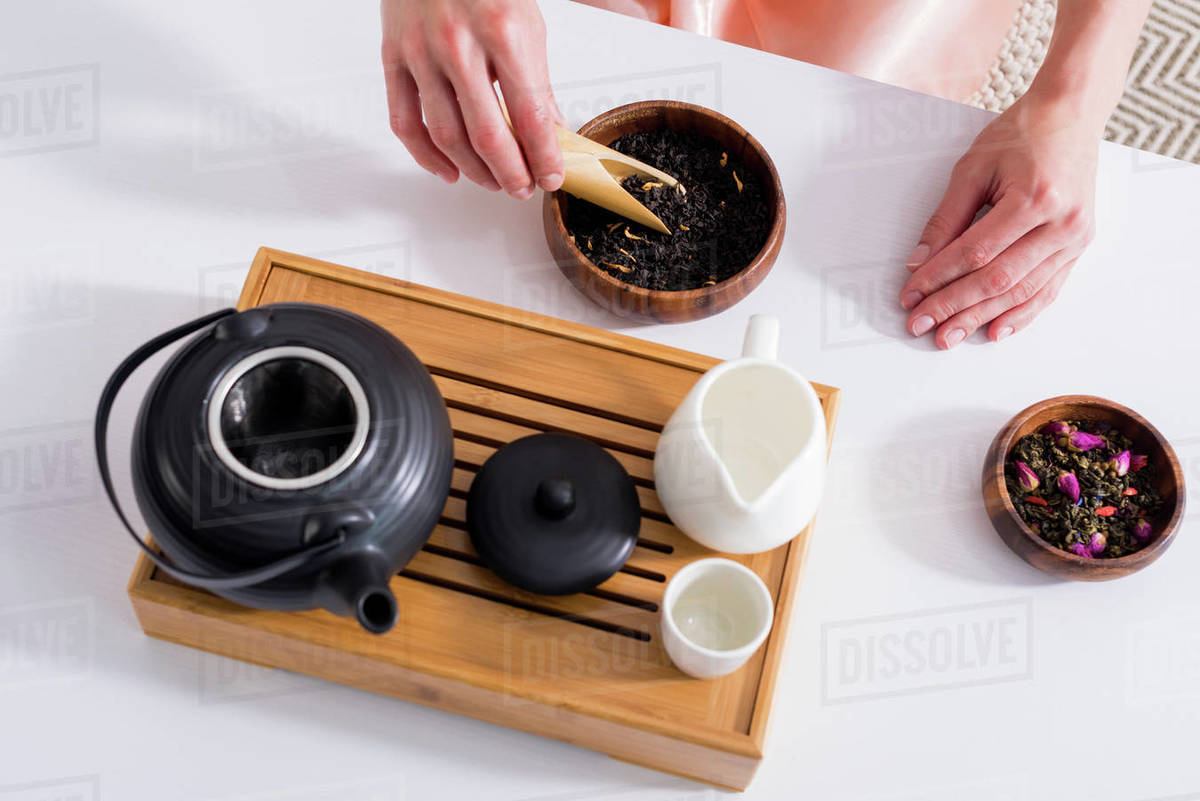 Cropped shot of woman making tea while having tea ceremony in morning
