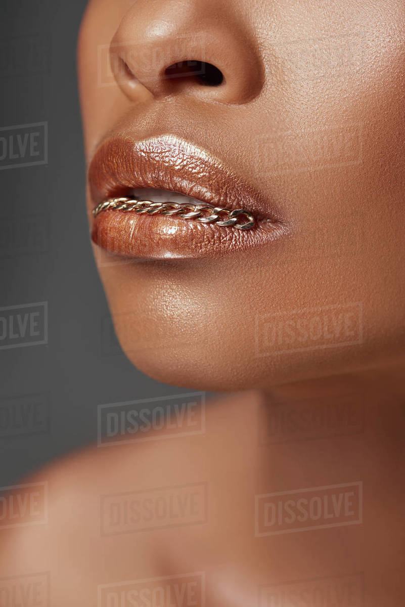 cropped shot of african american woman with chain in mouth isolated on