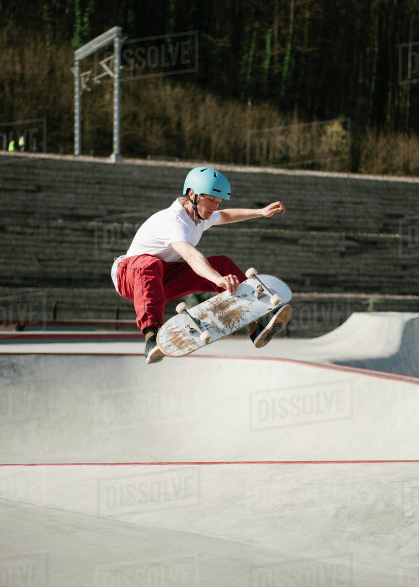 Young man performing midair trick on skateboard Stock Photo Dissolve