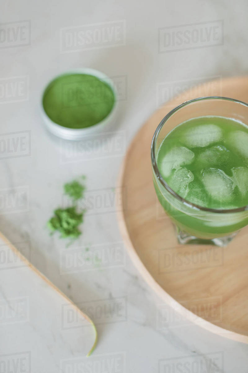 Overhead view of a glass of iced matcha drink, matcha powder and matcha spoon Stock Photo