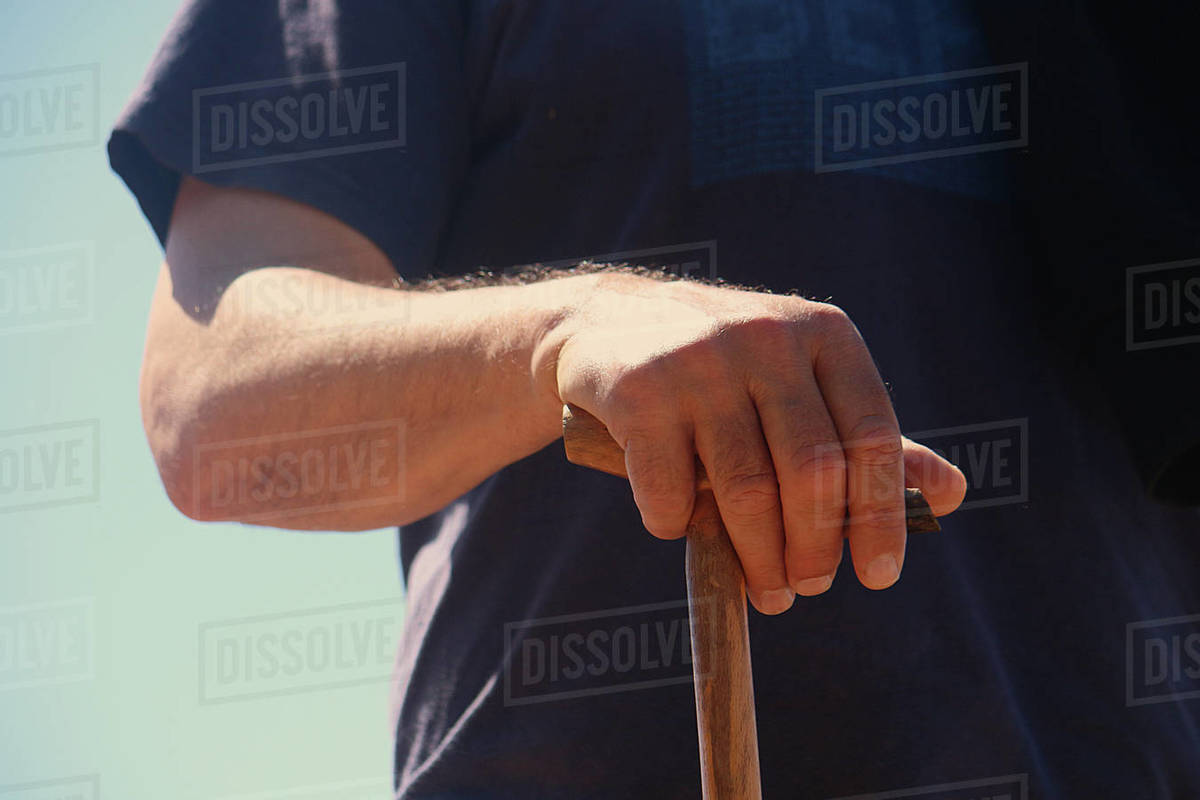 Closeup of a senior man holding a walking stick Stock Photo Dissolve