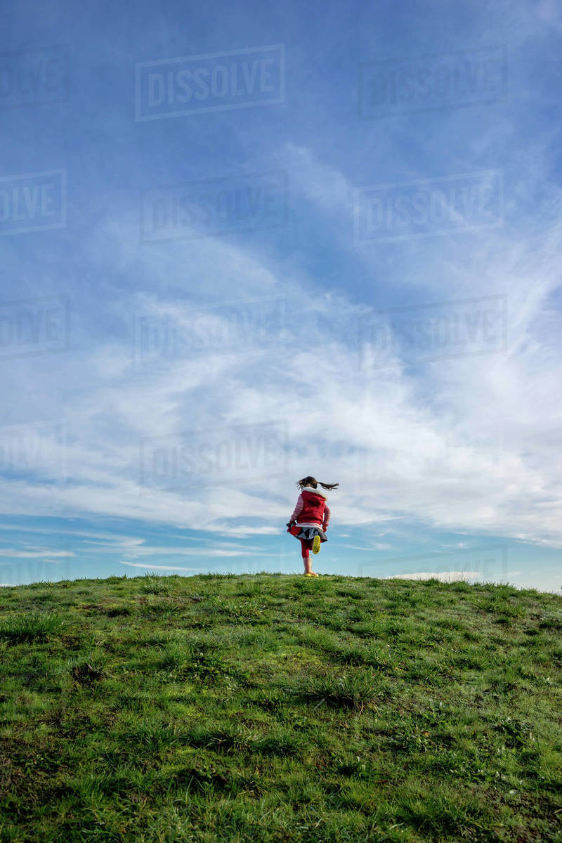 Girl on a hill spinning around Stock Photo Dissolve