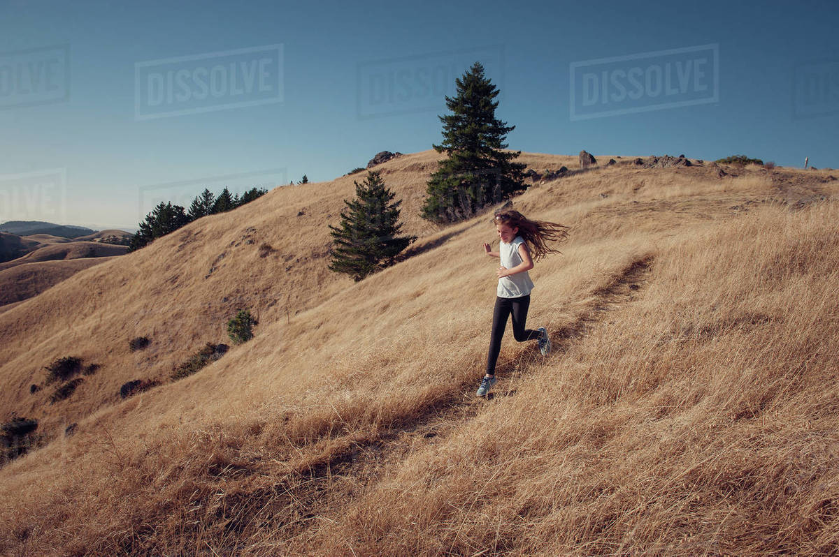 Girl running down mountain, California, America, USA Stock Photo