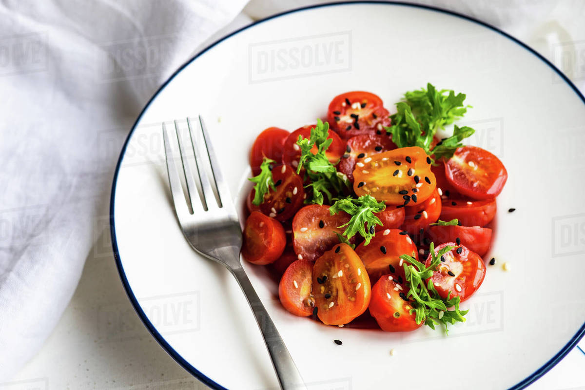 Tomato and rocket salad with sesame seeds Stock Photo Dissolve