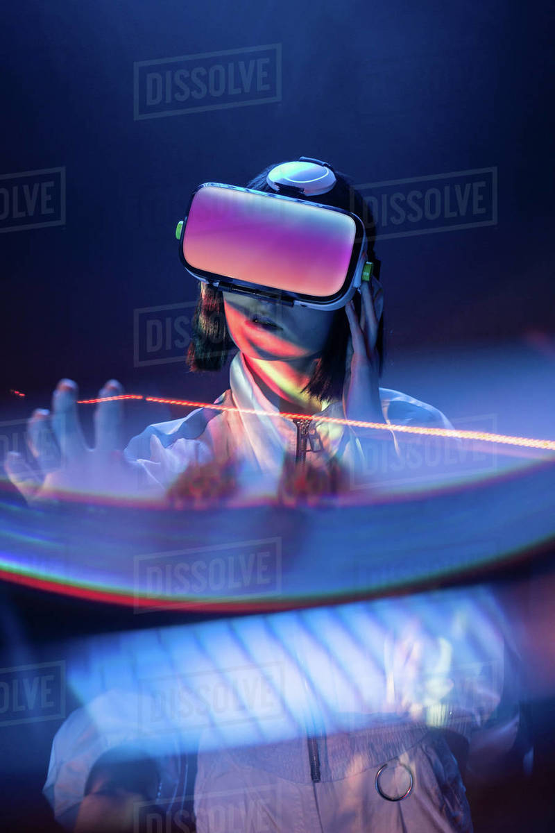 Excited young woman holding a prism while having virtual reality
