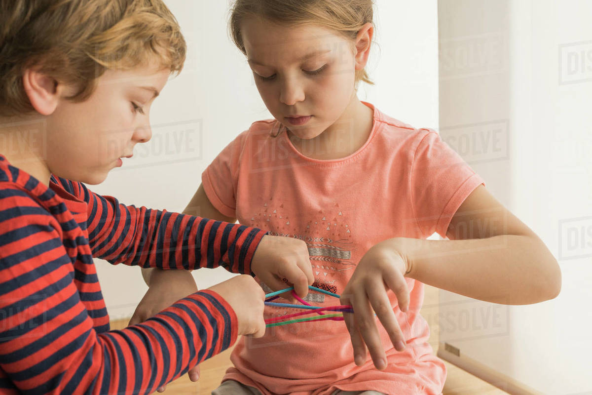 Smart children using rubber bands for game Stock Photo Dissolve