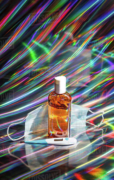 Glass of antiseptic liquid and forensic face respirator mask placed ...