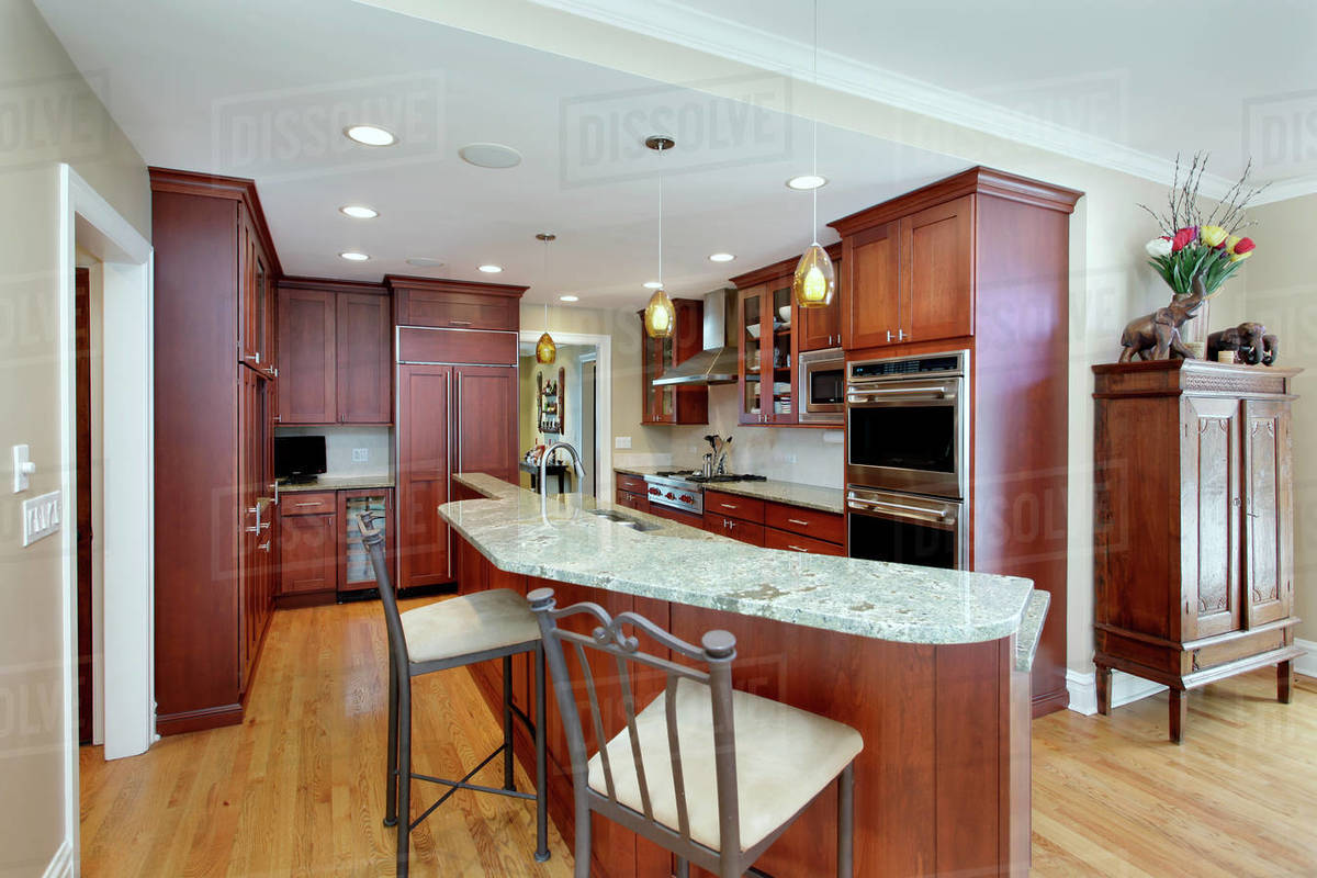 Modern kitchen with double decker island and cherrywood cabinetry ...