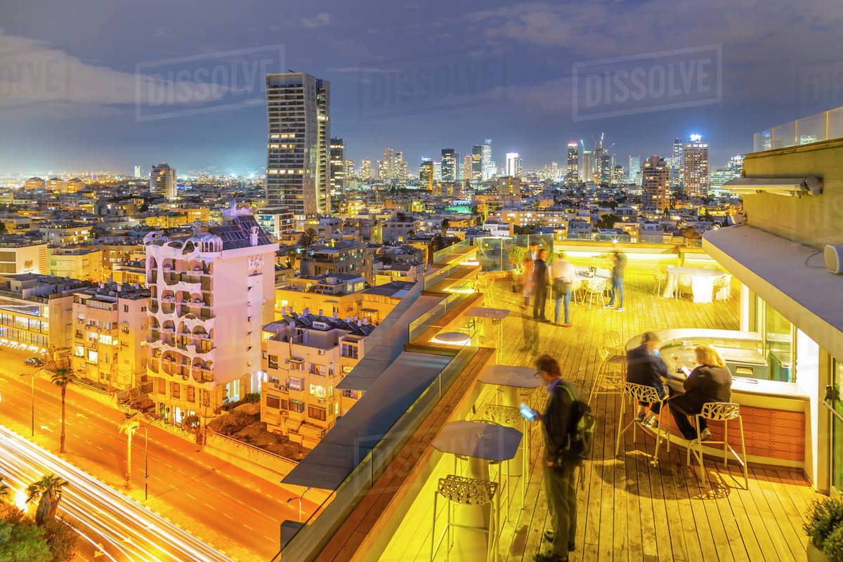 View of hotel rooftop bar and Tel Aviv skyline at dusk, Jaffa visible