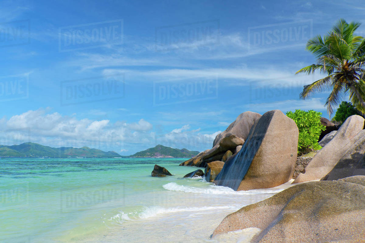 Waves swirling around large granite boulders and palm trees on Anse Source d'Argent, La Digue, Seychelles, Indian Ocean, Africa Royalty-free stock photo