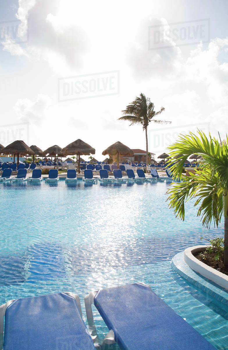 Playa Del Carmen, Cancun, Quintana Roo, Mexico - Lounge chairs and shade umbrellas around a pool on a beach. Royalty-free stock photo