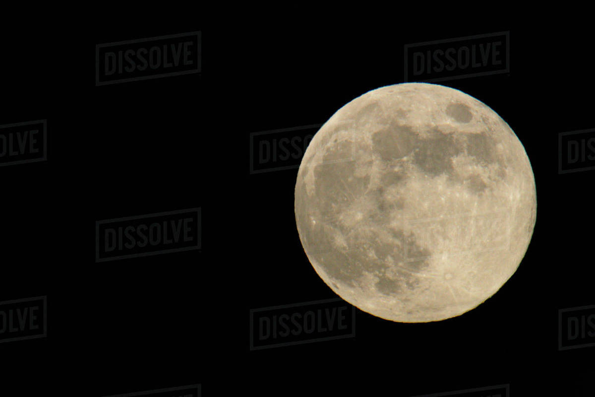 full moon with yellowish hue to right of frame stock photo dissolve
