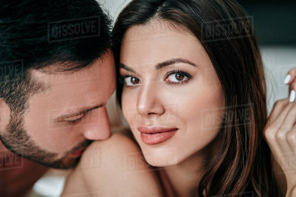 The attractive man kissing woman shoulder - Stock Photo - Dissolve