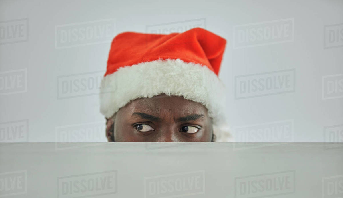 The african man in the santa hat watching from the table Royalty-free stock photo