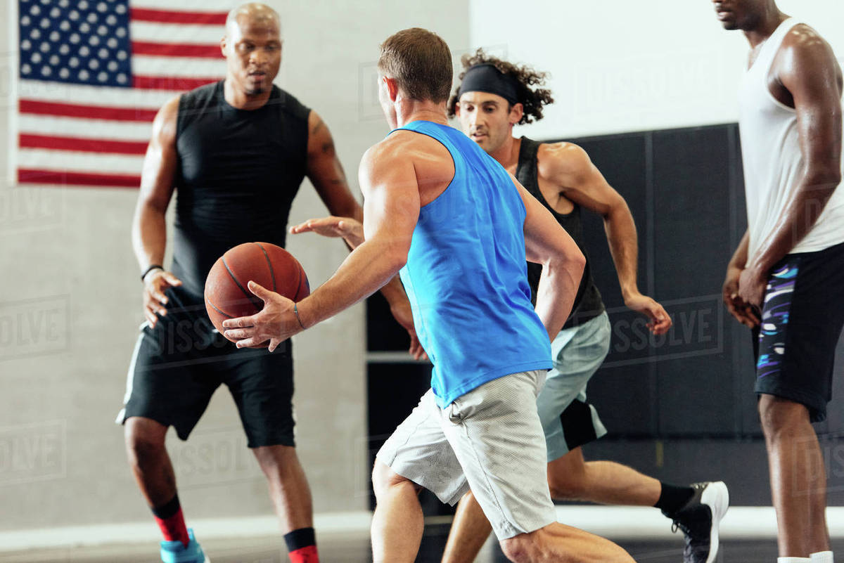 Male basketball player running with ball in basketball game Stock Photo Dissolve