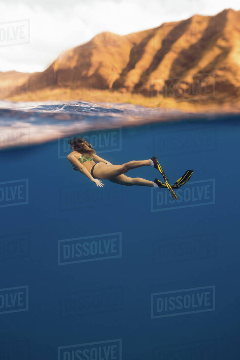 Woman wearing flippers swimming underwater, Oahu, Hawaii, USA Stock