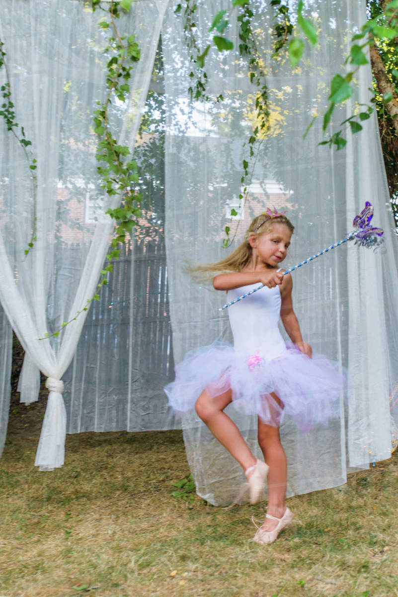 Portrait of young girl, dressed as fairy, holding butterfly wand Royalty-free stock photo