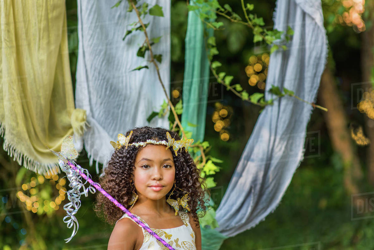 Portrait of young girl dressed as fairy, holding wand Royalty-free stock photo
