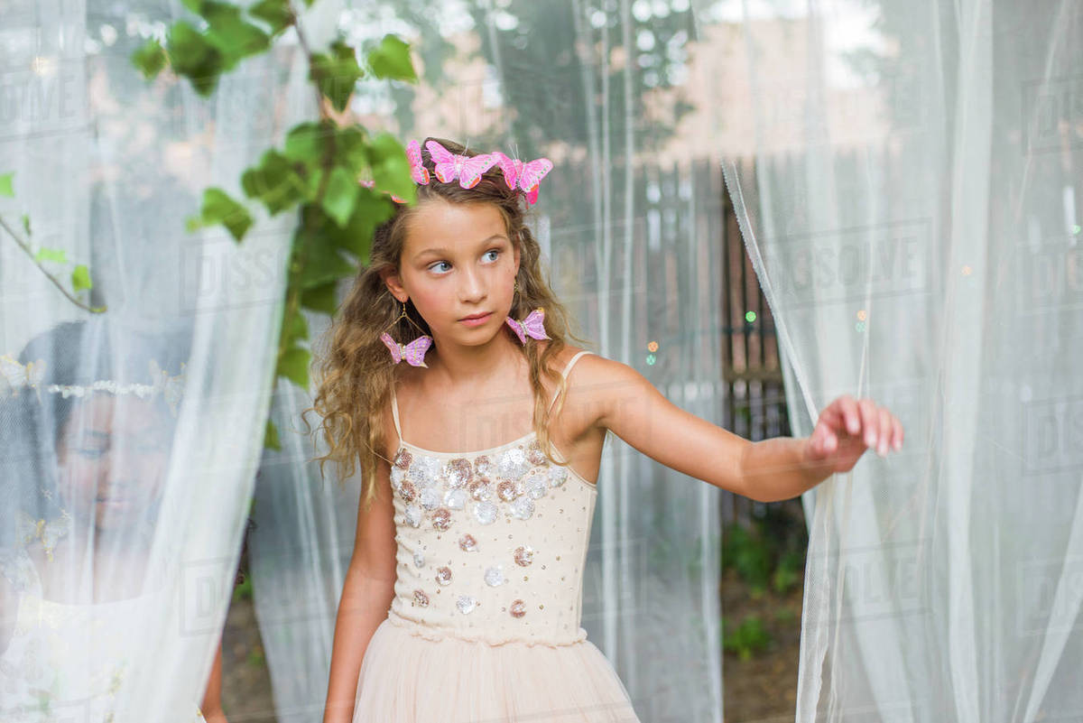 Portrait of young girl dressed as fairy, walking through sheer material Royalty-free stock photo