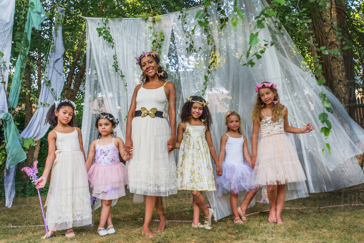Portrait of mature woman with group of young girls, dressed as fairies, outdoors Royalty-free stock photo