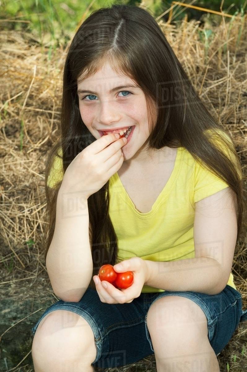 Girl eating cherry tomatoes Stock Photo Dissolve