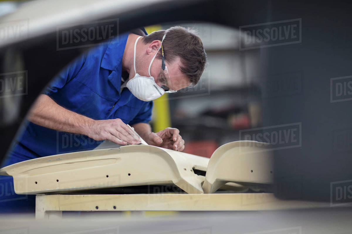 Car mechanic sanding car door in repair garage Stock Photo Dissolve
