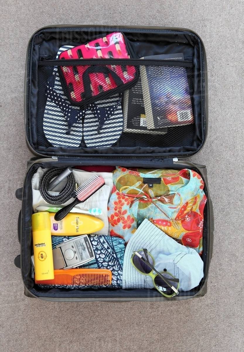 Suitcase packed for vacation Stock Photo Dissolve