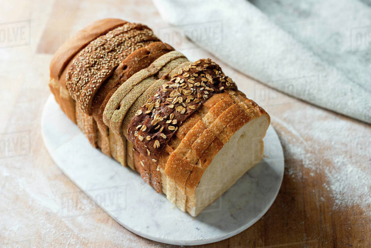 Sliced loaf made up of variety of white and wholemeal slices on cutting