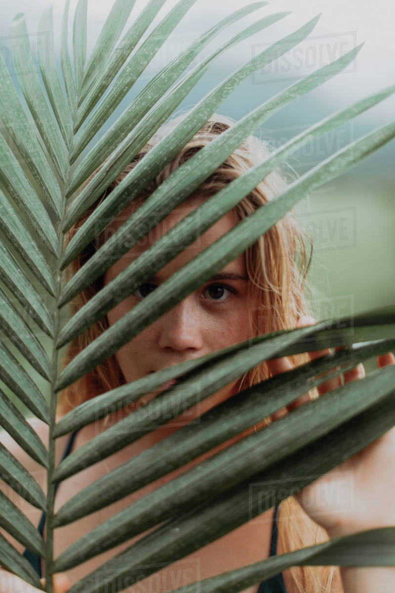 Woman in bikini holding large leaf, Princeville, Hawaii, US Stock