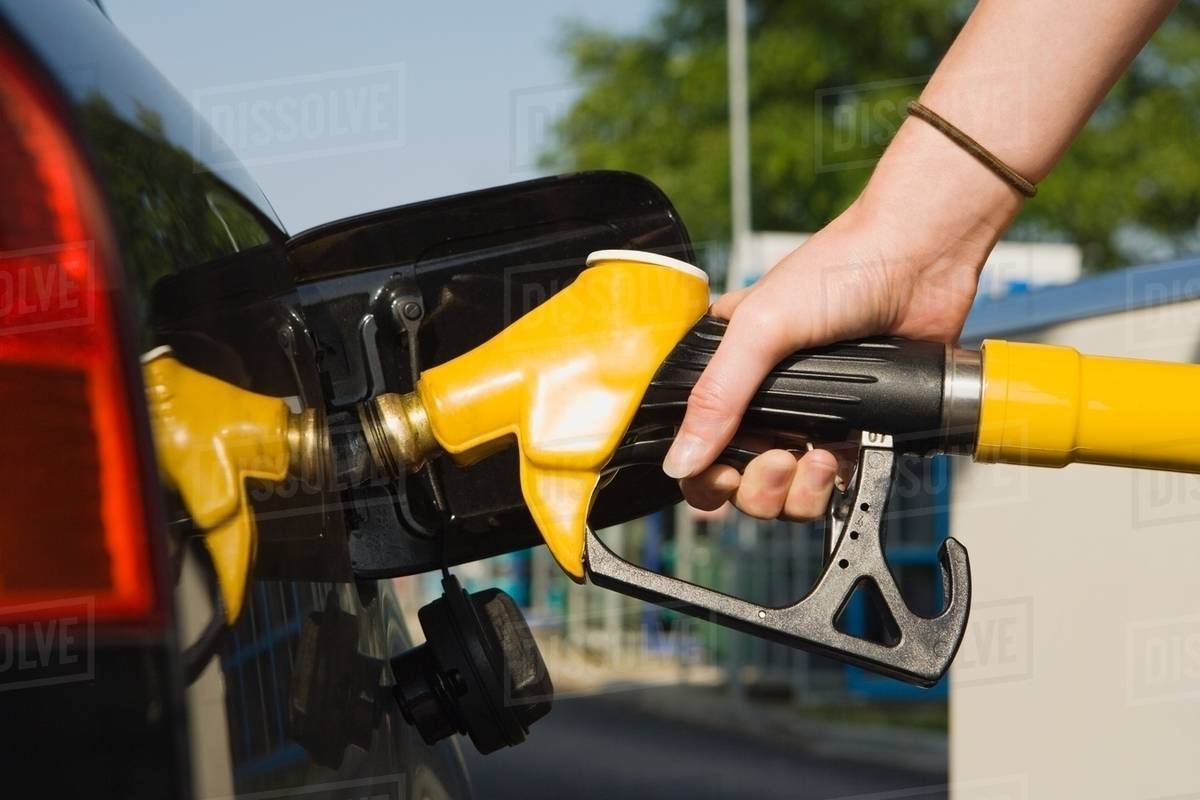Person using petrol pump Stock Photo Dissolve