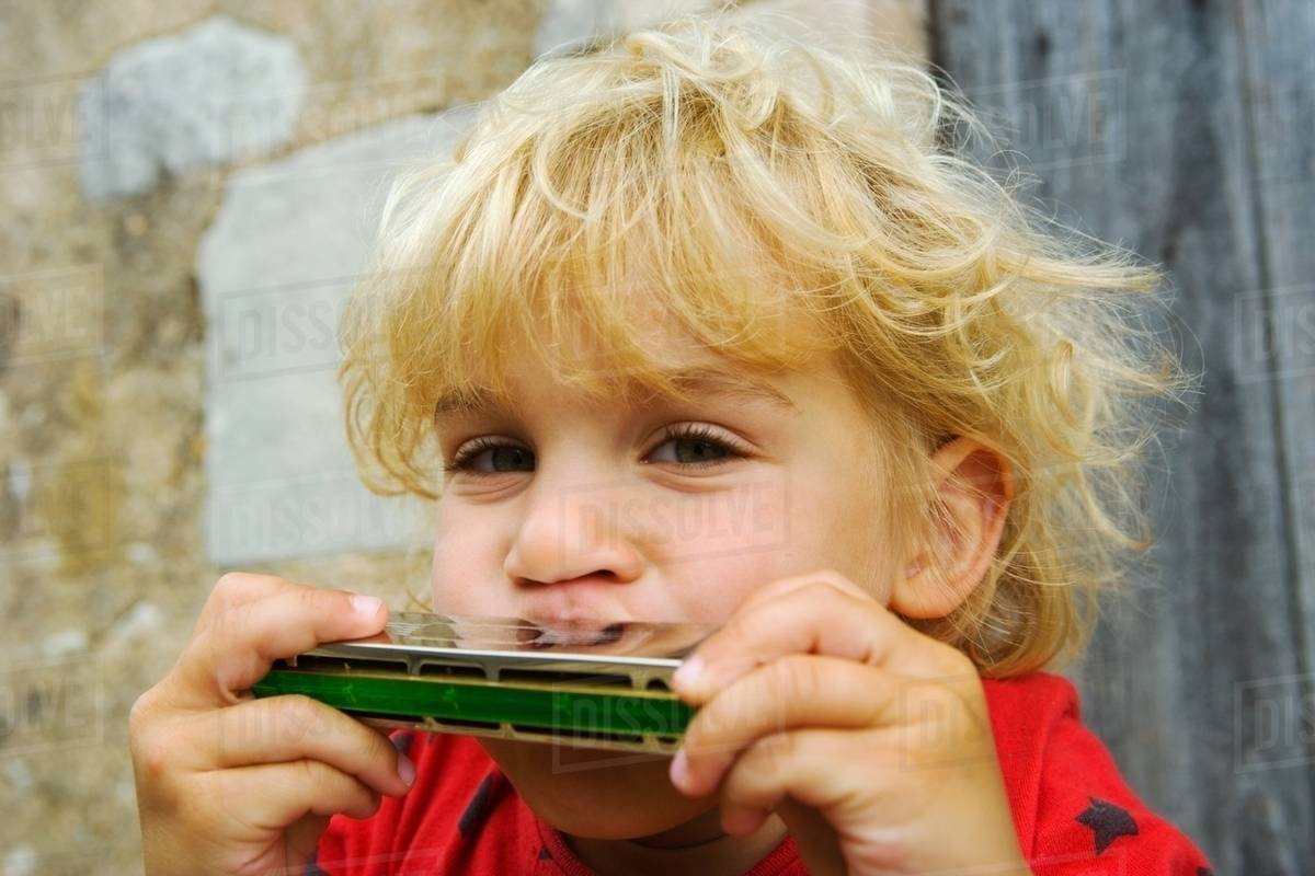 A boy playing the harmonica Stock Photo Dissolve