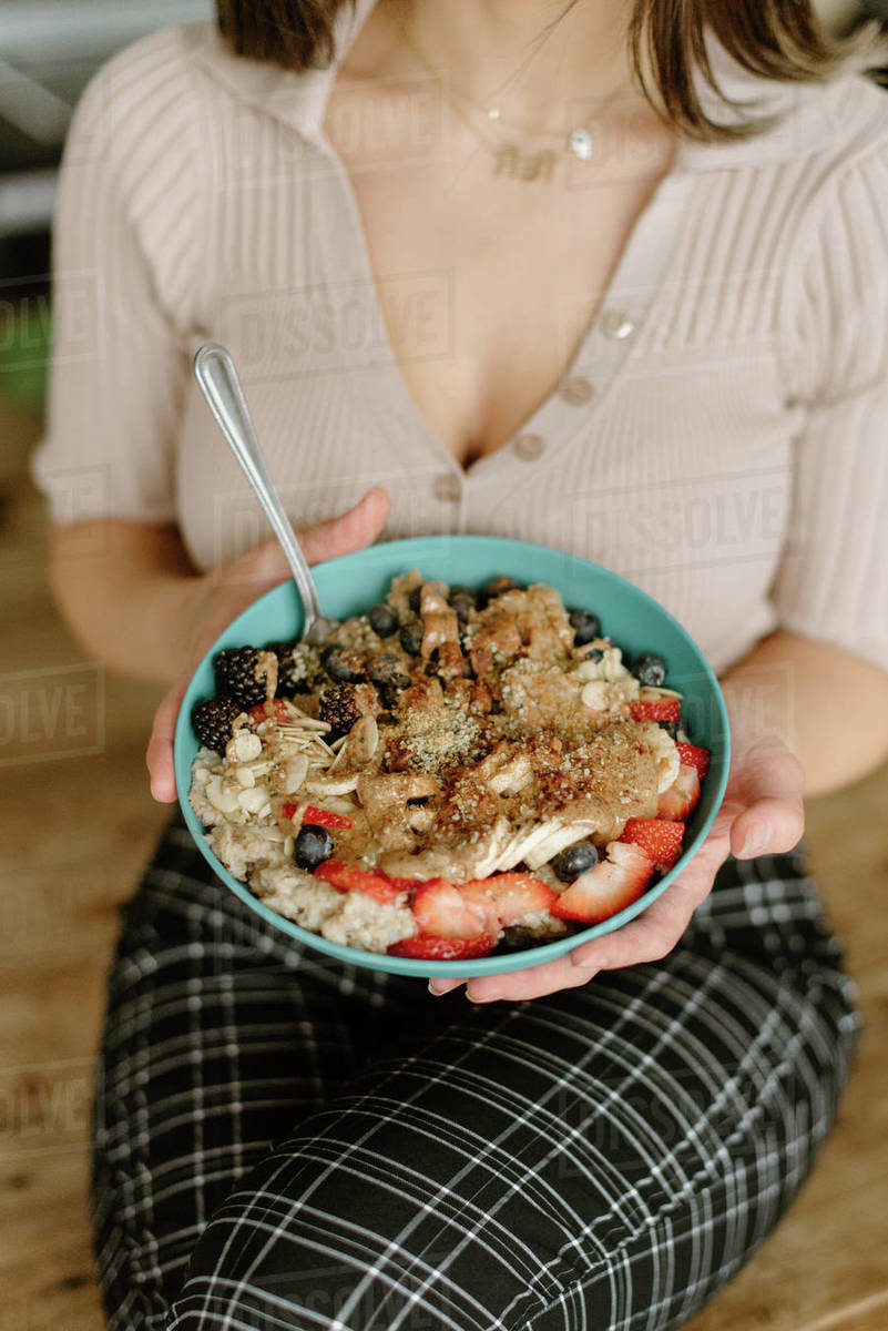 Woman holding granola bowl Stock Photo Dissolve